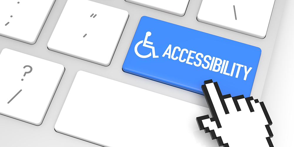 Tastatur mit blauer Taste samt Aufschrift "Accessibility" und Rollstuhlfahrer-Symbol. Der Cursor-Finger zeigt darauf.