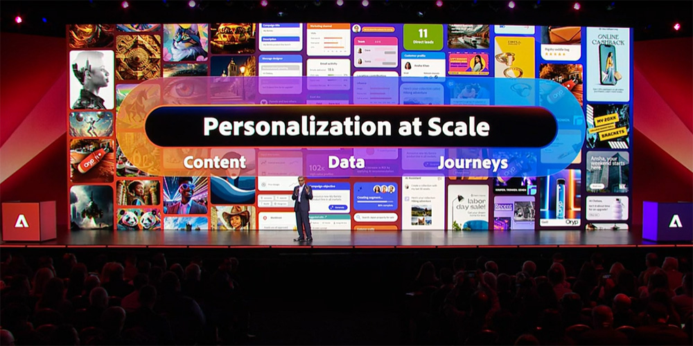 Bühne auf dem Adobe Summit mit Screen-Aufschrift "Personalization at scale"