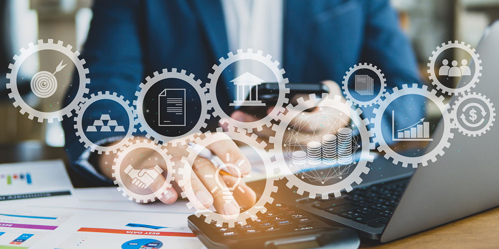 Geschäftsperson arbeitet am Laptop und Smartphone, umgeben von digitalen Symbolen für Datenintegration, Finanzen und Prozesse – Sinnbild für die ERP- & PIM-Integration im E-Commerce.