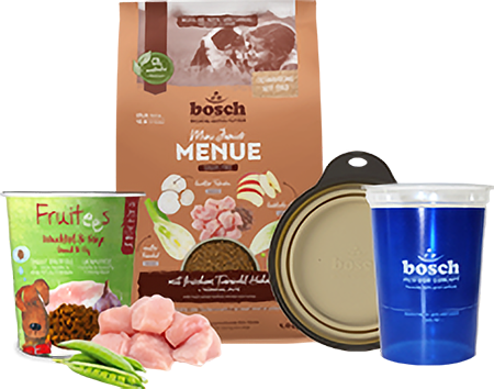 Auswahl an bosch Tiernahrung-Produkten speziell für Züchter: Hundefutter aus der Serie 'Menue', Frucht-Snacks 'Fruities', frische Fleischstücke, ein Napfdeckel und ein blauer Trinkbecher mit bosch-Logo.
